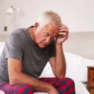Man facing depression around men's health issues on bed