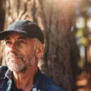 Prostate cancer patient sitting outside by tree
